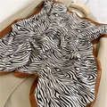Detail of zebra print silk scarf with brown border on a beige wool coat fabric - Coffee Edge Stripes