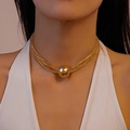 Detalle de gargantilla dorada de varias capas con un gran colgante de esfera metálica pulida - Collar / Dorado