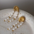 Goldene Spiral-Ohrringe mit Süßwasserperlen auf einem natürlichen Steinsockel - Gold