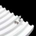 Detail of silver heart stud earrings with petal screw backs on a wavy white tray - Heart