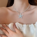 Detail of blue starfish pendant on beaded necklace worn by a model in soft lighting - Seed Bead Resin Starfish Pendant Style (9#)