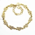 Detailed macro shot of golden olive leaf bracelet with sparkling cubic zirconia inlay - Olive Leaf / Gold