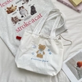 Detail of cute brown bear embroidery and drawstring closure on a white canvas tote bag - Cloud Animal