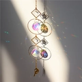 Hanging crystal suncatcher with moon star pendant creating rainbow light on plain wall - No. 1