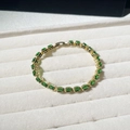 Detalle de pulsera con piedras ovaladas verde esmeralda en soporte de terciopelo - Oro de 18K / Circonita Verde Dorada