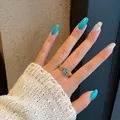 Vintage gold heart ring with blue opal stone and zircon accents on model hand - Adjustable Open / Blue Faux Opal