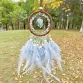 Handmade dreamcatcher with green crystal and blue feathers hanging in a park setting - Green Aventurine Brown Hoop
