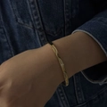 Gros plan du bracelet ondulé en or avec incrustation de zircon sur poignet féminin - Style Diamant Motif Vague (A1196) / Or