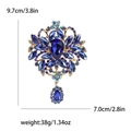Elegante spilla a fiore dorata con gocce di cristallo blu e strass scintillanti - Blu
