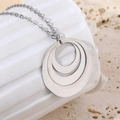 Close-up of triple interlocking oval rings pendant on a wavy white stone pedestal - Steel Color (N05285S)