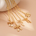 Detailed view of five-piece gold layered bow necklaces on a soft stone background - Bow / Five-Piece Set / Gold