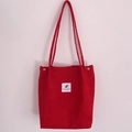 Red corduroy tote bag with vertical stripes, a white fabric patch and long shoulder straps - Red