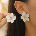 Elegant white floral earrings with golden center detail worn by a model - White Flower Earrings with Gold Stamens (11415)