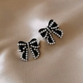 Macro shot of elegant black bow earrings with white pearls on champagne silk fabric - 67# Black Bow Pearl Studs