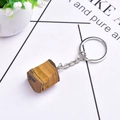 Macro view of a natural tiger eye stone keychain with brown fibrous texture and silver ring - Tiger's Eye