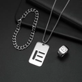 Makroaufnahme von silbernem Titanschmuck-Set mit E-Anhänger und eleganter Gliederkette - Set E