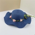 Navy blue wide-brim woven straw hat featuring pink rose floral trim and foliage decoration - Navy Blue