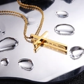 Collar de cruz de acero dorado con grabado religioso sobre superficie de espejo - Dorado