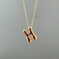 Detailed close-up of a polished gold letter H pendant necklace with a liquid metal effect - Letter H Single Pendant
