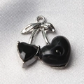 Macro shot of cherry-shaped jewelry charm with black faceted stones and silver metal loop - Style 33