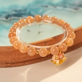 Close-up of natural sunstone beaded bracelet with a colorful enamel rocking horse charm - Sunstone Enamel Rocking Horse Bracelet