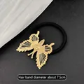 Minimalistisches Haargummi mit goldenem Schmetterling-Charm und schwarzem Gummiband - Hohler Schmetterling Gold