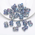 Iridescent blue and purple bear-shaped crystal charms in a white ceramic bowl - Transparent Blue