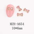 Dettaglio del fiocco per nail art con strass rosa 10x6mm e base in metallo dorato - Stile Fiocco (A654)
