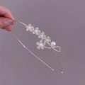 Detailed close-up of zircon flower headband with pearls and sparkling wavy metal wires - Flower