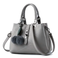 Grey pebbled faux leather handbag with white geometric stitching and pom-pom charm - Light Gray
