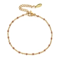 Macro detail of gold stainless steel chain bracelet with red-brown beads and lobster clasp - Gold Reddish Brown