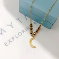 Detailed macro view of 18k gold moon pendant necklace on a blue jewelry gift box - Moon Pendant Gold Beads (N123月亮-金色)