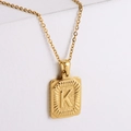 Macro shot of 18K gold plated stainless steel rectangle pendant with embossed letter K - Letter K