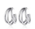 Macro detail of triple-layer polished silver hoop earrings with minimalist C-shape design - Silver