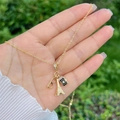 Dettaglio della collana dorata con ciondoli a forma di Torre Eiffel, occhiali e macchina - Torre Eiffel