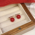 Minimalist gold bar earrings with glossy red beads displayed in a wooden jewelry box - Bright Red Beads With Gold Bar