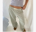 Detail view of sage green striped wide-leg trousers featuring elastic waist with brand label - XS / Bottoms / Light Green
