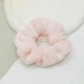 Close-up of soft pink faux rabbit fur scrunchie on a white decorative tray - Pink