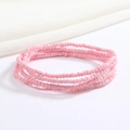Close-up of pink handmade seed bead elastic body chain with matte finish on white linen - Pink