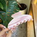 Macro view of pink marble acetate hair claw clip showing smooth texture and teeth - Large / Pink Buttercream