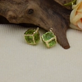 Close-up of green resin crystal pendants with gold metal frames on a natural background - Yellow & Green
