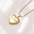 Close-up of golden heart locket necklace with Te Amo engraving on white silk background - TE AMO Engraved