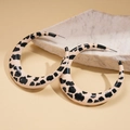 Macro detail of geometric leopard print earrings on a light decorative stone - Leopard/Cow Print (Beige) / Beige
