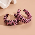 Primer plano de aretes de aro rosa con estampado de leopardo y textura de cuero - Rosa