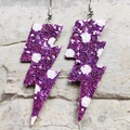 Dettaglio di orecchini a forma di fulmine glitterati viola con motivi a pois bianchi - Viola a Pois Glitter