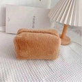 Detailed view of brown plush cosmetic bag with soft texture and smooth metal zipper - Camel