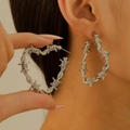 Detail of silver heart hoop earrings featuring a unique twisted barbed wire texture - Silver Barbed Heart Large Hoop Earrings (2675)