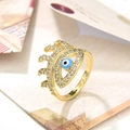 Primer plano de un anillo de ojo turco dorado con perla azul y circonitas brillantes - Ojo azul oscuro