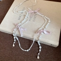 Elegant pearl necklace featuring pink polka dot ribbon bows and crystal teardrops - White Pearl Pink Bow