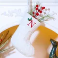 White knitted Christmas stocking with red embroidered letter N and holly leaves - Letter N / White